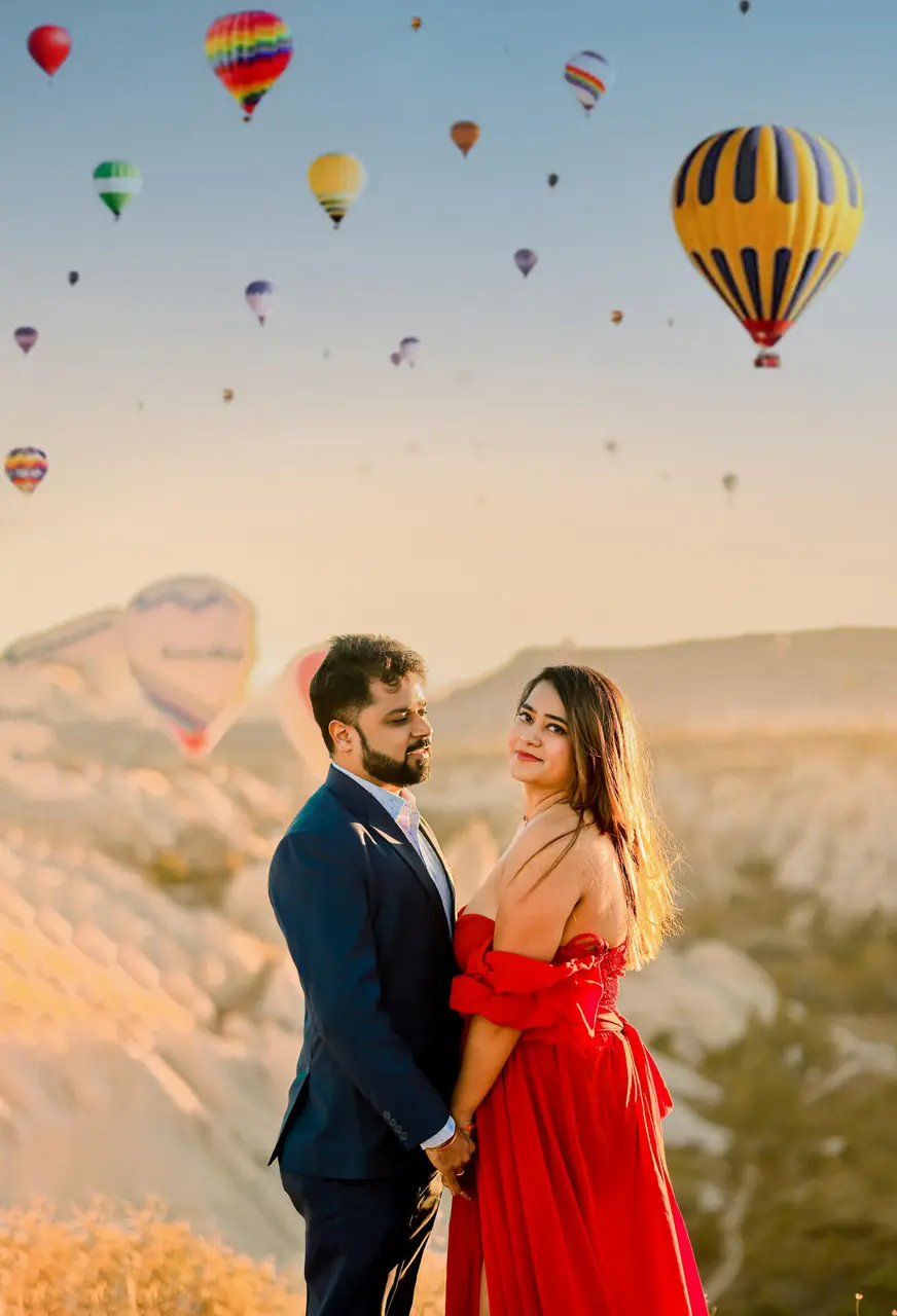 Couple at sunrise with hot-air balloons